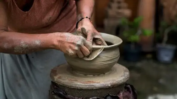 A skilled potter shaping clay on a wheel, showcasing traditional craftsmanship and creativity.