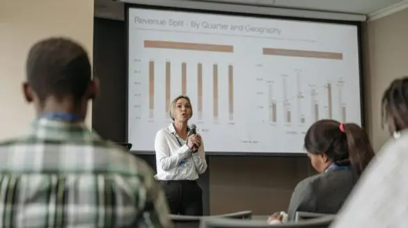 Professional presentation on revenue split by quarter and geography during a business conference.