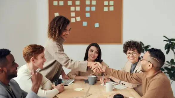 Diverse team collaborating in a meeting, showcasing teamwork and cooperation in a modern workplace.