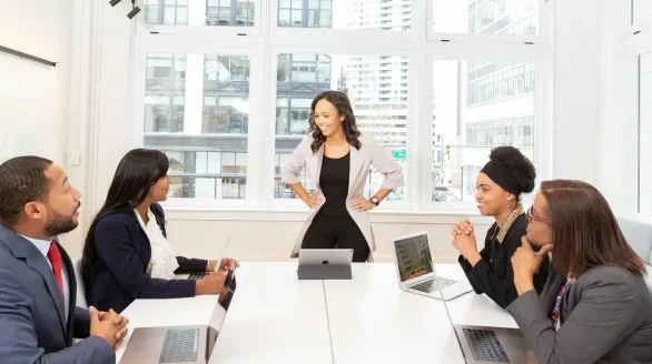pexels-photo-1367276-1367276 Diverse team engaged in a business meeting with laptops in a modern office setting.