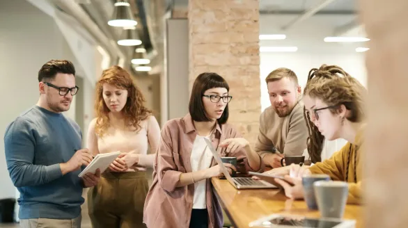 pexels-photo-3182826-3182826 A diverse group of coworkers in a modern office engaged in teamwork using technology.